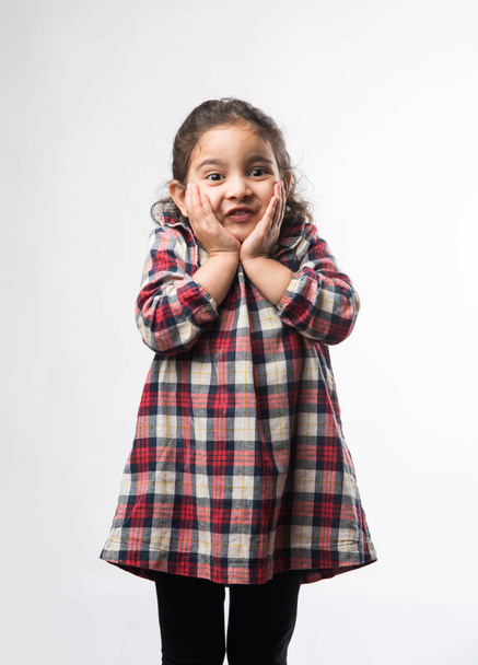 Happy / excited Indian Little kid girl with open mouth looking with surprised expressions. Standing isolated over white background - Foto, Imagem