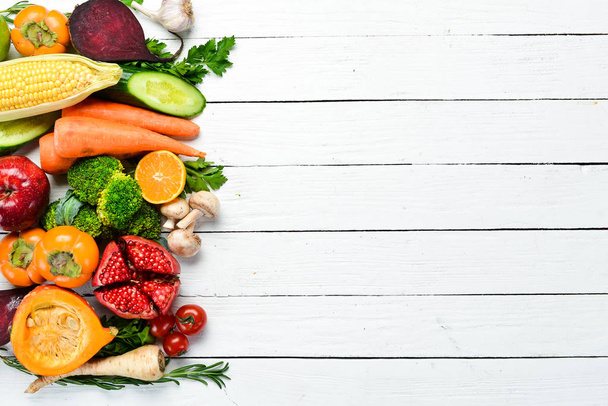 Frutas y verduras frescas sobre fondo de madera blanca. Comida saludable. Vista superior. Espacio libre de copia
. - Foto, Imagen