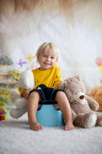 Cute toddler boy, potty training, playing with his teddy bear  - Fotografie, Obrázek