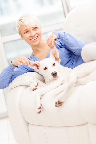 Blonde woman is playing with her dog - Photo, Image
