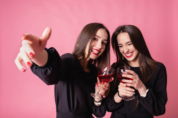 Two women celebrate the New Year party having fun laughing and drinking wine. - Photo, Image