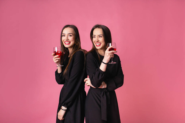 Δύο γυναίκες γιορτάζουν την Πρωτοχρονιά διασκεδάζοντας γελώντας και πίνοντας κρασί. - Φωτογραφία, εικόνα