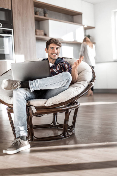 young man uses a laptop in his modern apartment. - Fotó, kép