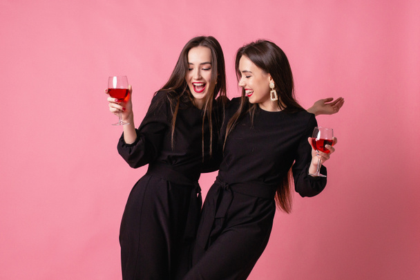 Δύο δίδυμες-γυναίκες γιορτάζουν την Πρωτοχρονιά διασκεδάζοντας γελώντας.. - Φωτογραφία, εικόνα