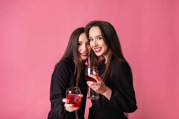 Két nő ünnepli az újévi partit, jól érzik magukat nevetve és bort iszogatva.. - Fotó, kép