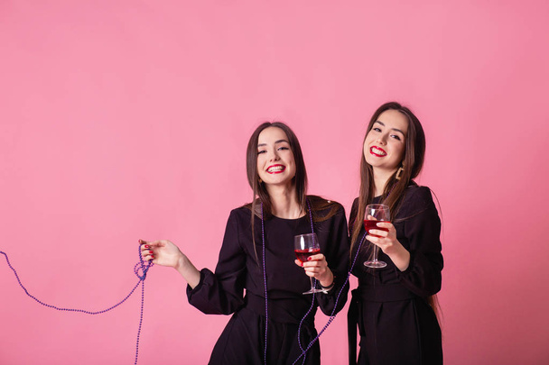 Két nő ünnepli az újévi partit, jól érzik magukat nevetve és bort iszogatva.. - Fotó, kép