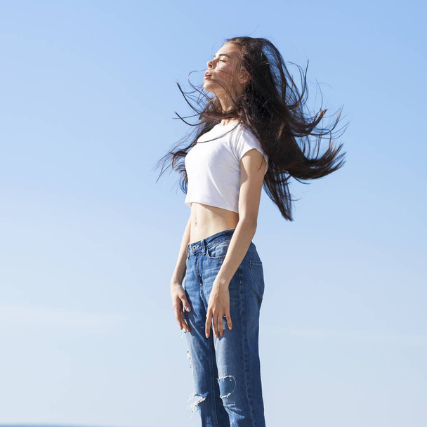 Beautiful brunette woman posing against blue sky bright sunny we - Foto, Imagen