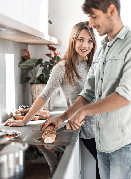 young couple preparing sandwiches in their kitchen - 写真・画像