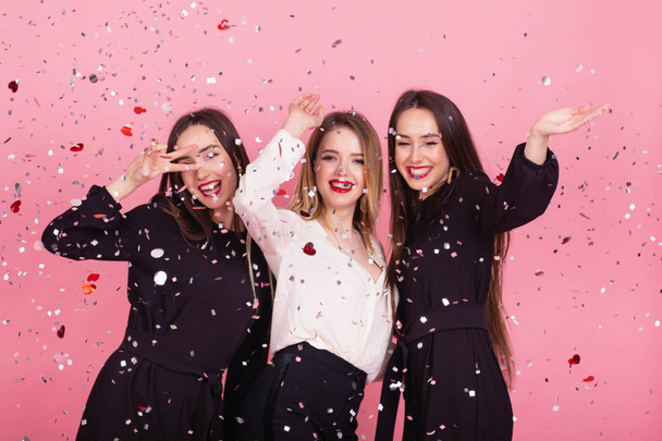 Tre donne festeggiano il Capodanno divertendosi a ridere sotto i coriandoli volanti
. - Foto, immagini