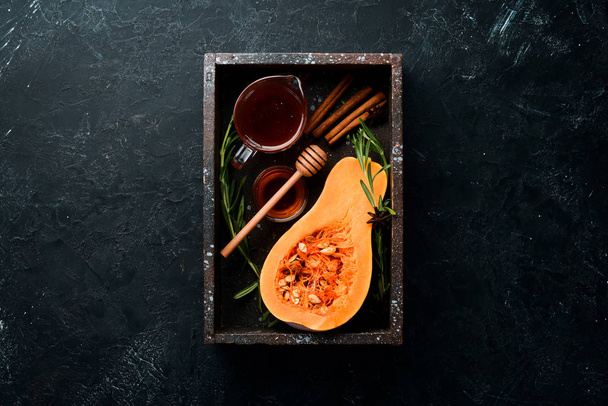 Fresh pumpkin with honey, healthy food. On a black stone background. Top view. Free copy space. - Photo, image