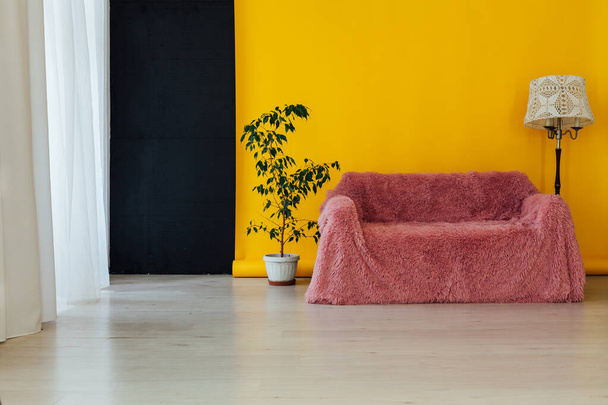 розовый диван в интерьере комнаты с желтым фоном
 - Фото, изображение