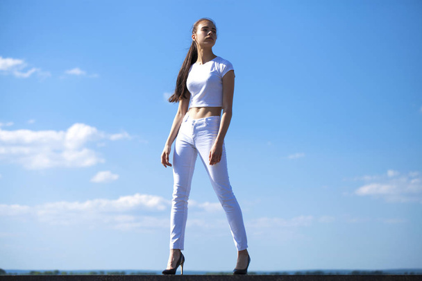 Beautiful brunette woman posing against blue sky bright sunny we - Foto, immagini