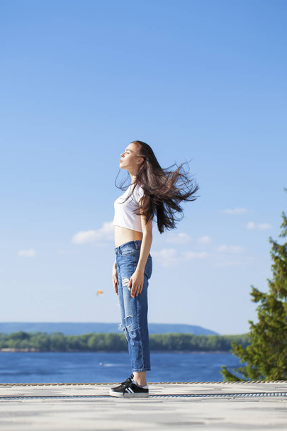 Beautiful brunette woman posing against blue sky bright sunny we - 写真・画像