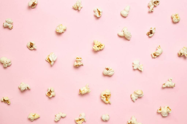 Top view of popcorn pattern on pink background. Unhealthy diet concept. - Photo, image