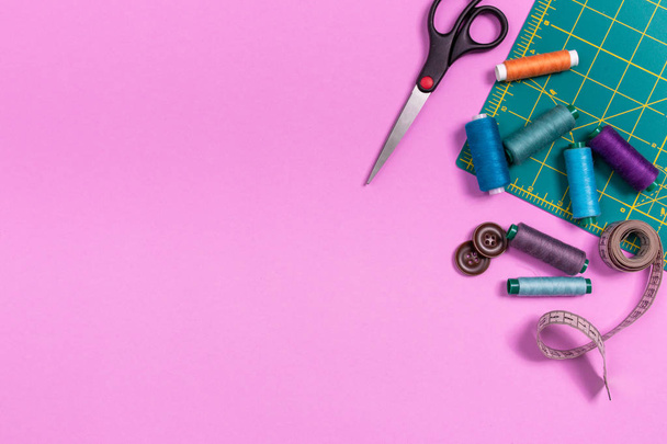 Sewing accessories on a plastic pink background. Top view, flatlay - Photo, Image