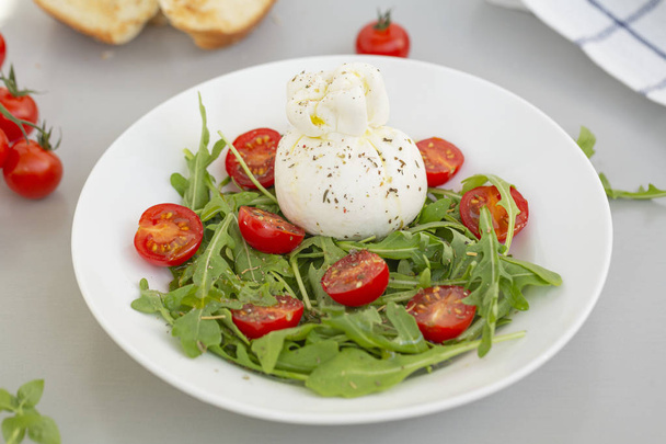 Fresh Salad with Italian burrata cheese, arugula, cherry tomatoes and olive oil. Healthy eating. Selective focus  - Photo, Image