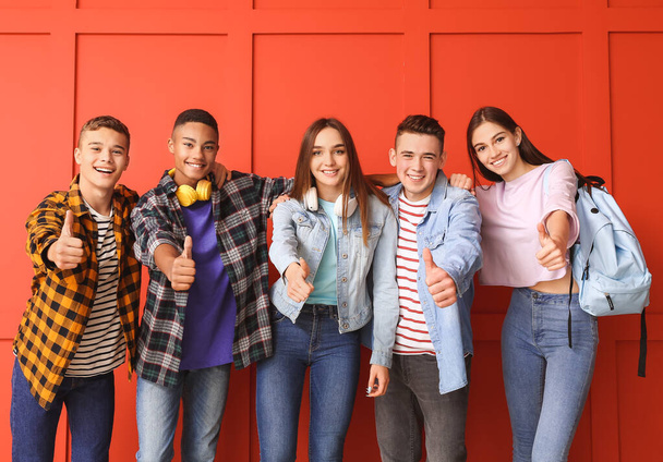 Portrait of teenagers showing thumb-up on color background - Photo, Image