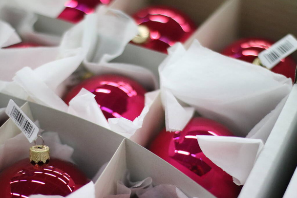 Χριστουγεννιάτικες διακοσμήσεις κόκκινες μπάλες σε χάρτινο κουτί για τα Χριστούγεννα και το νέο έτος φόντο - Φωτογραφία, εικόνα