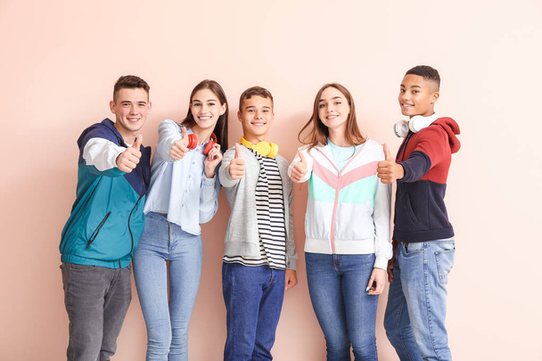 Porträt von Teenagern, die Daumen nach oben auf farbigem Hintergrund zeigen - Foto, Bild