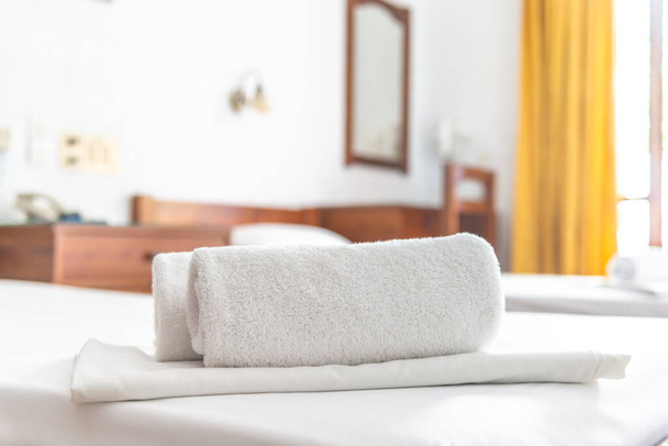 Two white towels are on the bed in hotel room. Close-up horizontal background. Space for text. - Valokuva, kuva