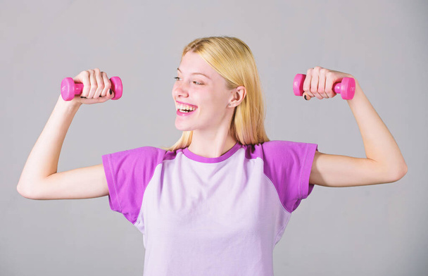 Easy exercises with dumbbells. Workout with dumbbells. Biceps exercises for female. Girl hold dumbbells. Fitness instructor. Healthy lifestyle concept. Woman fitness coach exercising with dumbbells - Foto, Bild