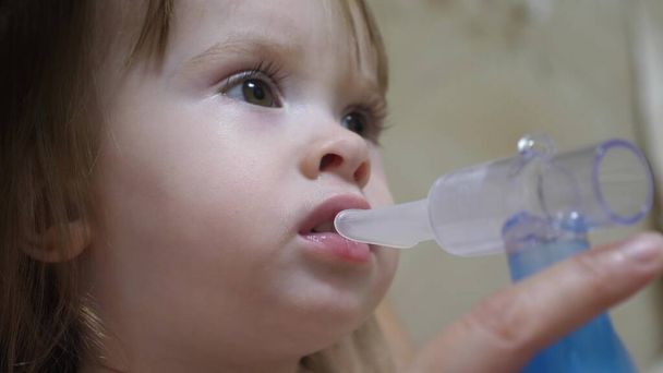 少女は病院で顔に吸入マスクで治療を受けた子供は病気で吸入器で呼吸する幼児は吸入蒸気を吸入することによってインフルエンザを扱います. - 写真・画像