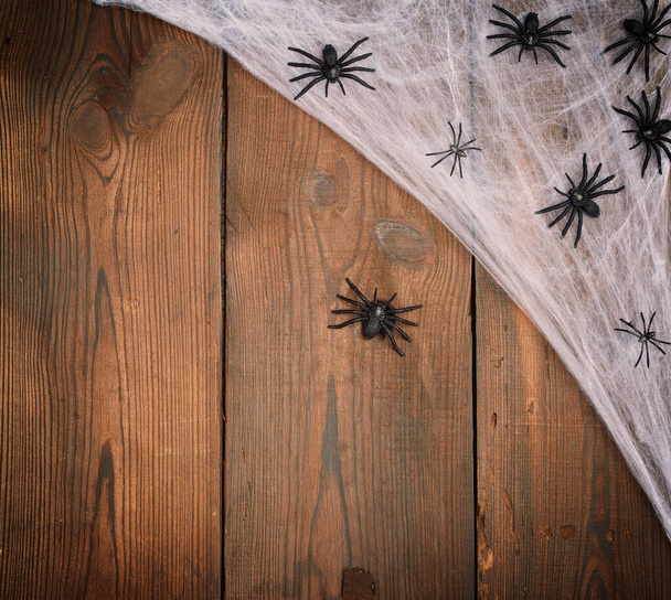 white spider web with black spiders on a wooden background from  - Фото, изображение