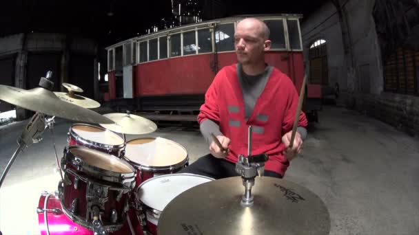 Fischauge Nahaufnahme eines Mannes, der im roten Outfit Schlagzeug spielt - Filmmaterial, Video