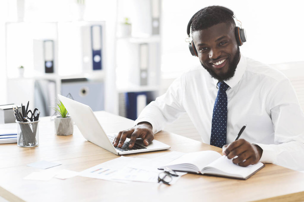 Счастливый чёрный бизнесмен изучает иностранный язык онлайн
 - Фото, изображение
