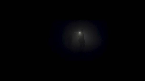 Un hombre solitario explorando una cueva profunda y oscura. Imágenes de archivo. Silueta de una persona de pie dentro de la cueva en el fondo de la luz de la luna mística
. - Foto, imagen