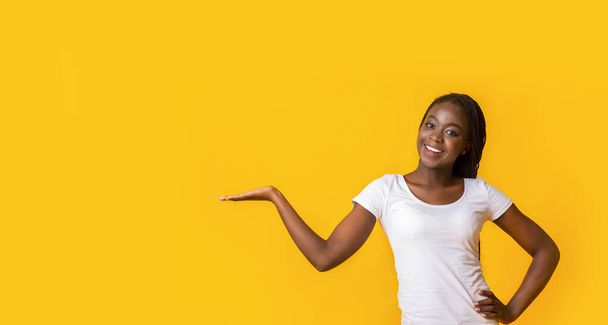 Cute black girl pointing with hand at empty space - Photo, Image