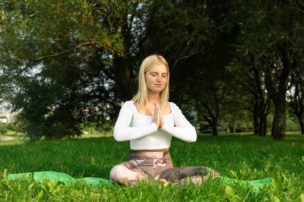The girl who meditates in the park in good summer weather - Photo, Image