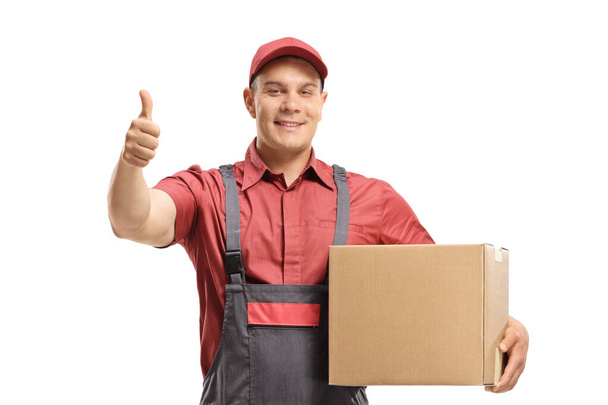Man mover holding a package and making a thumb up sign - Fotoğraf, Görsel
