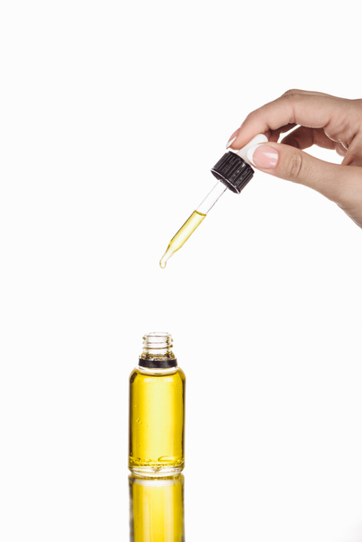 cropped view of woman holding dropper near bottle with natural serum isolated on white - Fotoğraf, Görsel