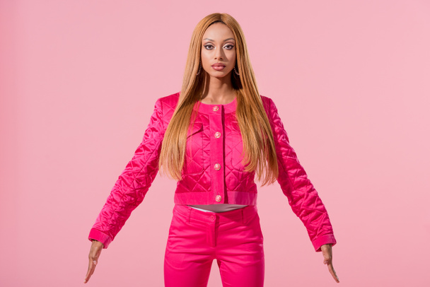 beautiful, stylish african american woman looking at camera isolated on pink, fashion doll concept - Foto, Imagem