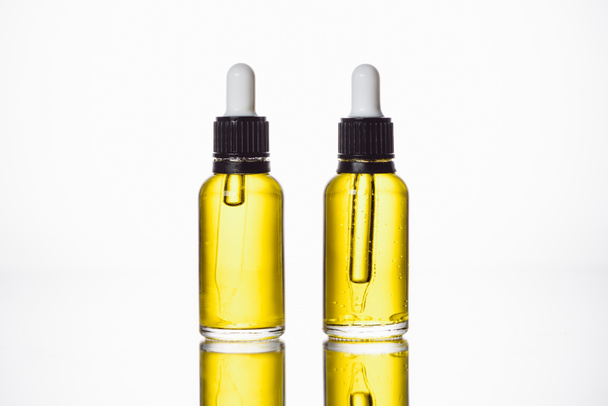 bottles with natural serum on surface with reflection isolated on white - Valokuva, kuva