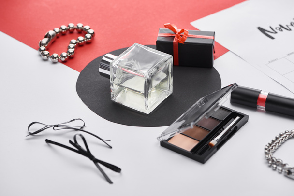 selective focus of perfume, eye shadow, gift, lipstick, bracelets, wristwatch and face powder  - Foto, afbeelding