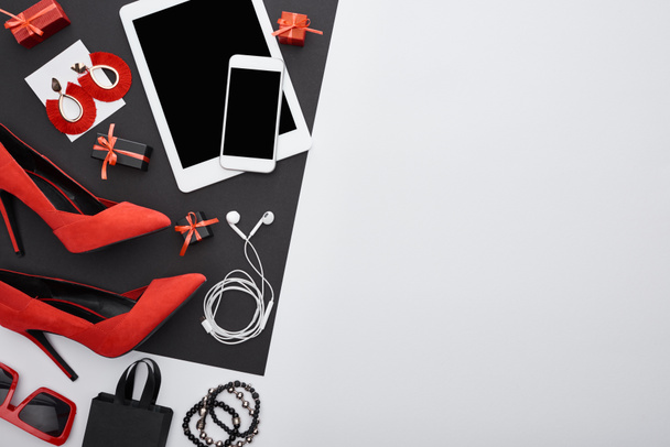 top view of heels, gadgets, gift boxes, sunglasses, earrings, earphones, bracelets, bag  - Zdjęcie, obraz