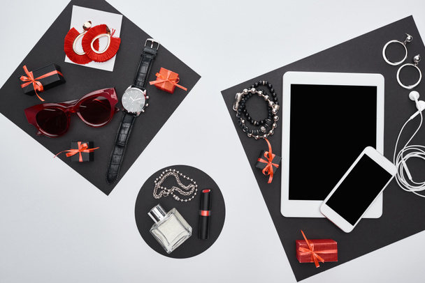 top view of gadgets, gift boxes, sunglasses, perfume, wristwatch, earrings, earphones, bracelets, lipstick - Foto, afbeelding