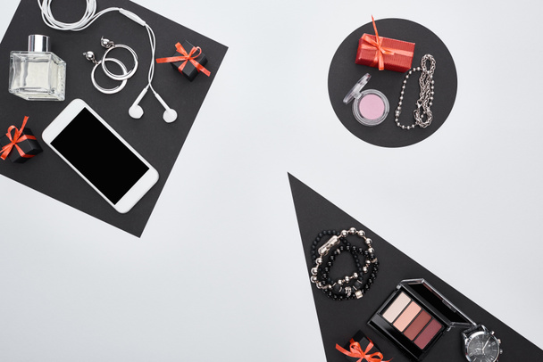 bovenaanzicht van gadget, geschenkdozen, parfum, armbanden, decoratieve cosmetica, oorbellen, oortelefoons - Foto, afbeelding