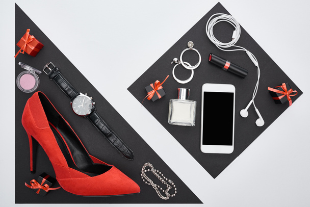 top view of gadget, gift boxes, perfume, bracelets, decorative cosmetics, earrings, earphones, wristwatch, shoes - Photo, Image