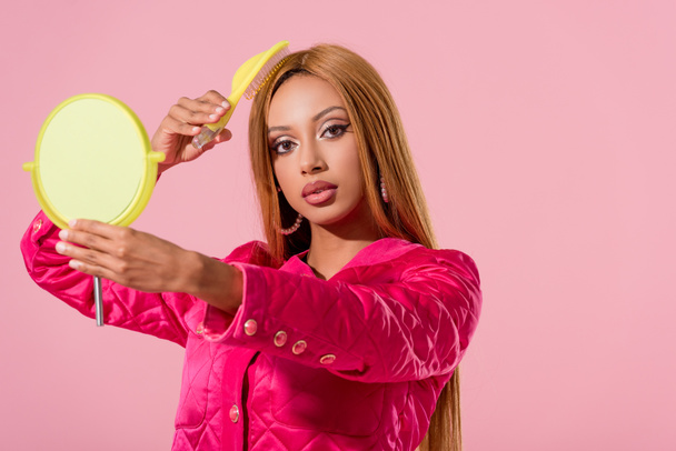 beautiful, trendy african american woman holding miror and combing isolated on pink, fashion doll concept - Photo, Image