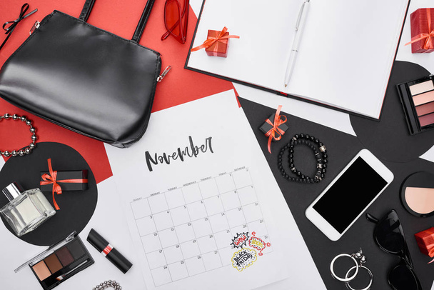 top view του ημερολογίου με επιστολόχαρτα Νοέμβριος, gadget, κουτιά δώρων, άρωμα, βραχιόλια, διακοσμητικά καλλυντικά, τσάντα, γυαλιά ηλίου, σκουλαρίκια, γυαλιά ηλίου  - Φωτογραφία, εικόνα