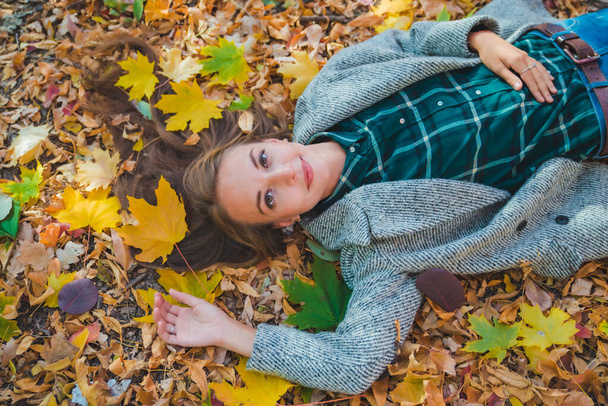 kobieta leżąca na ziemi jesienią żółte liście - Zdjęcie, obraz