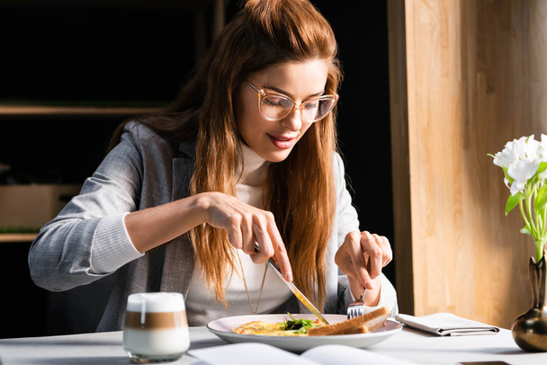 happy woman eating omelet for breakfast in cafe  - 写真・画像
