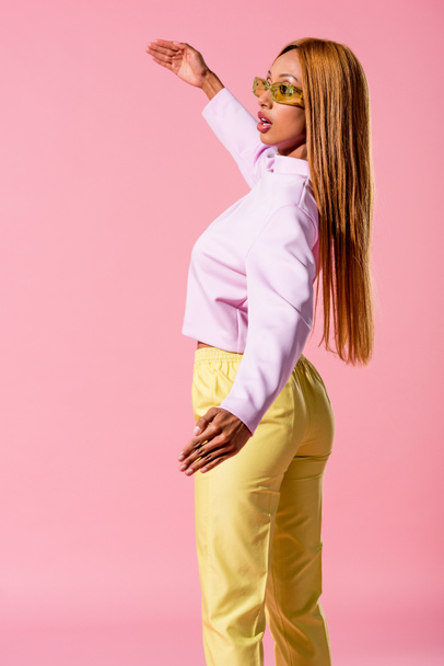 fashionable, blonde african american woman standing isolated on pink, fashion doll concept - 写真・画像