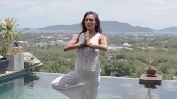 Turista calmo de pé em equilíbrio posar junto à piscina contra a cidade na costa tropical
 - Filmagem, Vídeo