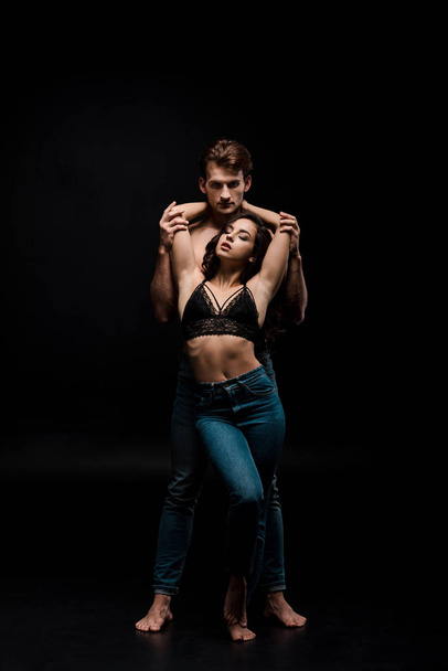 handsome passionate man hugging attractive woman, isolated on black - Fotoğraf, Görsel