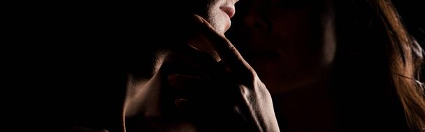 обрізаний вид ніжної пари, що обіймається, ізольований на чорному з підсвічуванням
 - Фото, зображення