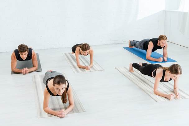 cinco jóvenes practicando yoga en postura de tablón de antebrazo
 - Foto, imagen
